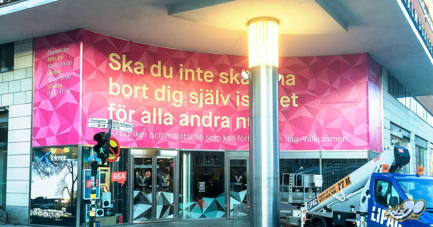Printad dekorfilm i rosa mönster med budskap över gallerians entré i Stockholm