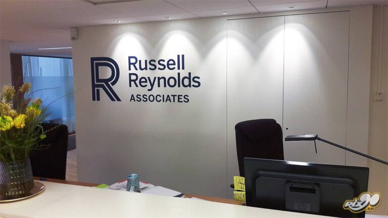 Logotyp till Russell Reynolds Associates på vägg bakom receptionsdisken