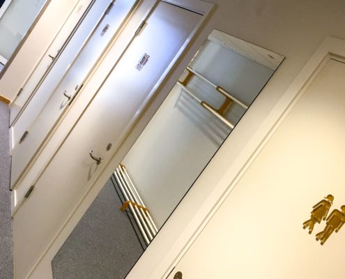 Toalettskyltar i akryl på dörrar med symboler för herr och dam på arbetsplats