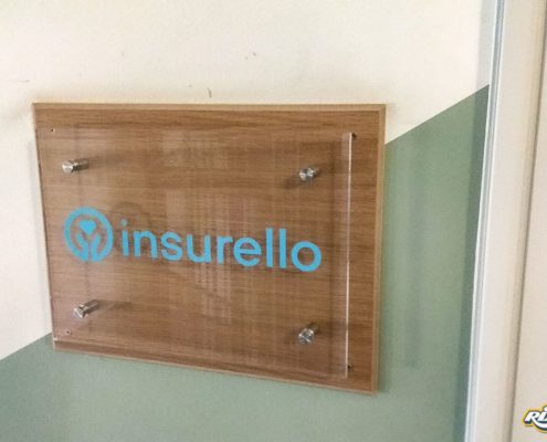 Logotyp på akrylskylt vid kundentré åt Insurello i Stockholm