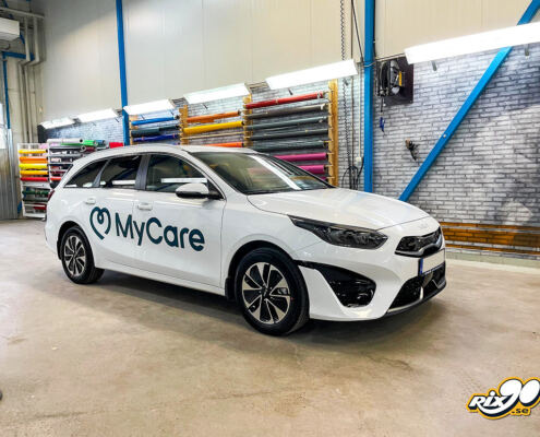 Bildekaler på dörrarna till tjänstebil Turkos logotyp på vit Kia Ceed kombi till MyCare, monterad i Rix90:s verkstad