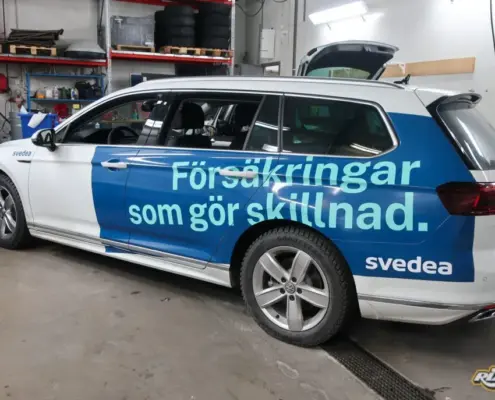 Större bildekaler med tydlig avsändare Blå halvfoliering med budskapet Försäkringar som gör skillnad på vit Volkswagen Passat till Svedea