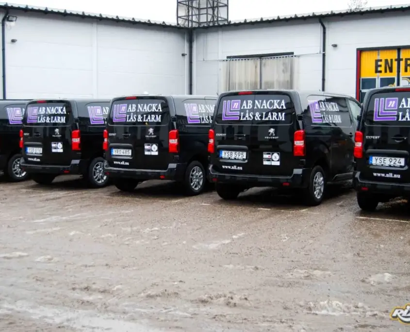 Lila och vit logotyp på fem svarta Peugeot Expert till AB Nacka Lås och Larm