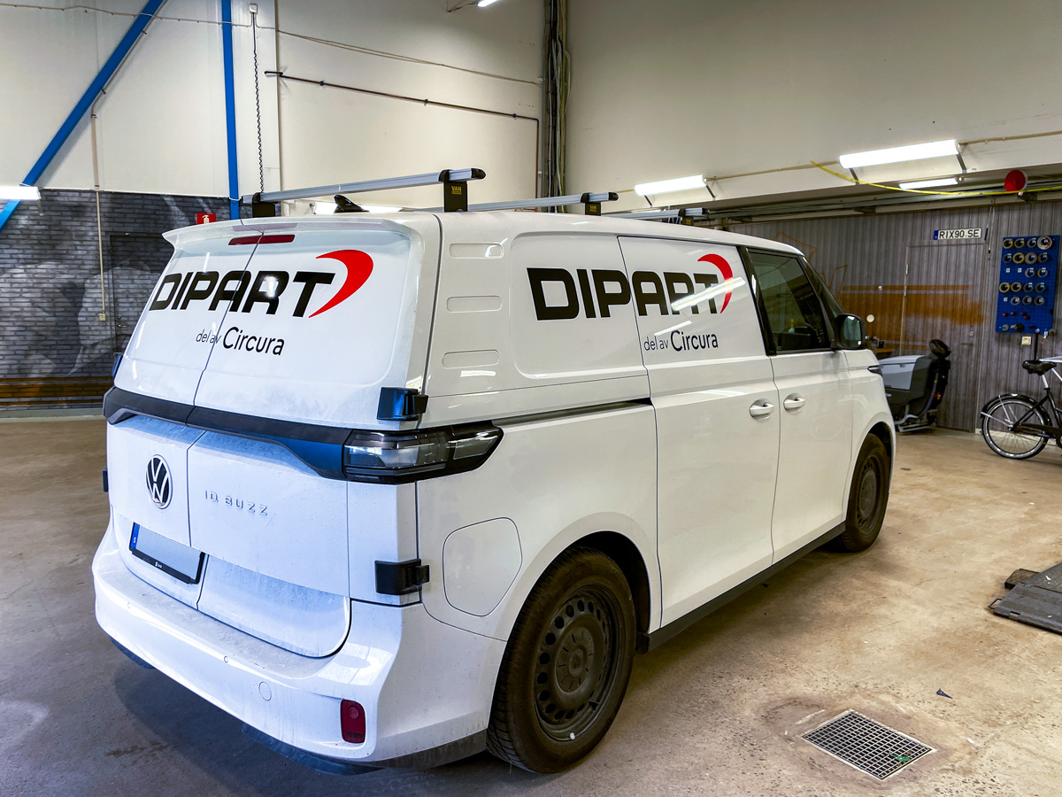 Bildekaler på VW ID. Buzz till Dipart Svart logotyp med röd båge och texten del av Circura på vit VW ID. Buzz till Dipart