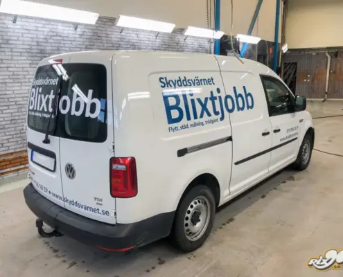 Bildekaler som smälter in i bilens egna färger Blå text på vit Volkswagen Caddy till Skyddsvärnets Blixtjobb